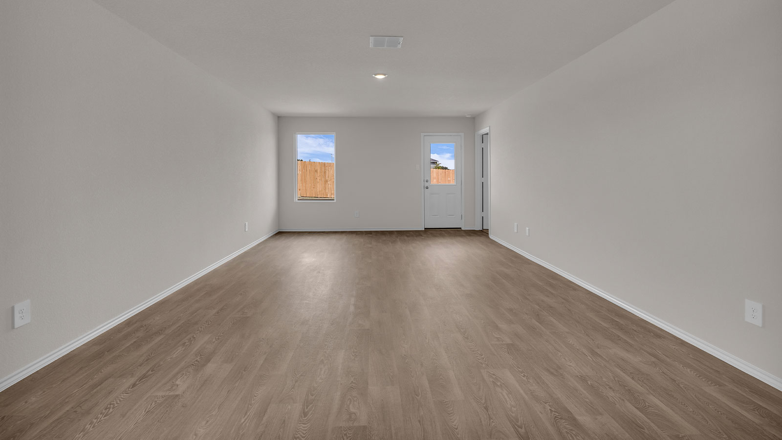 Living room with vinyl flooring, 2 windows, and  half lite exterior door.
