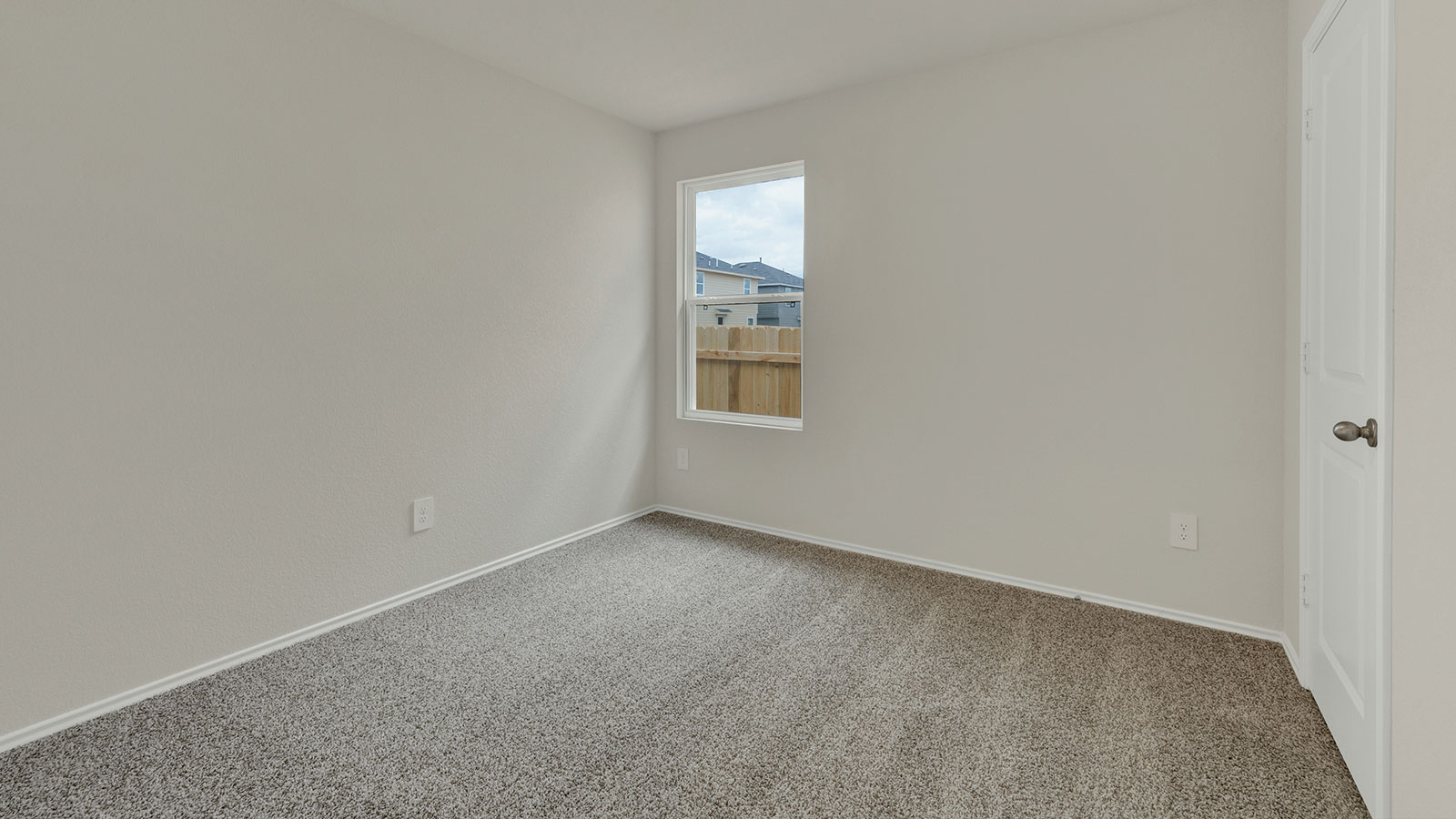Bedroom with carpeting and one window.