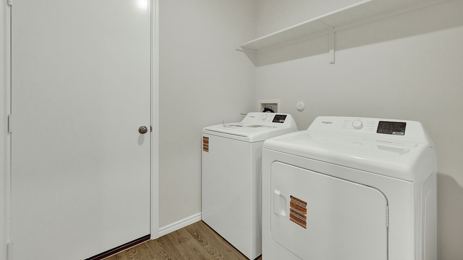 Laundry room with washer/dryer connections and wooden shelving.