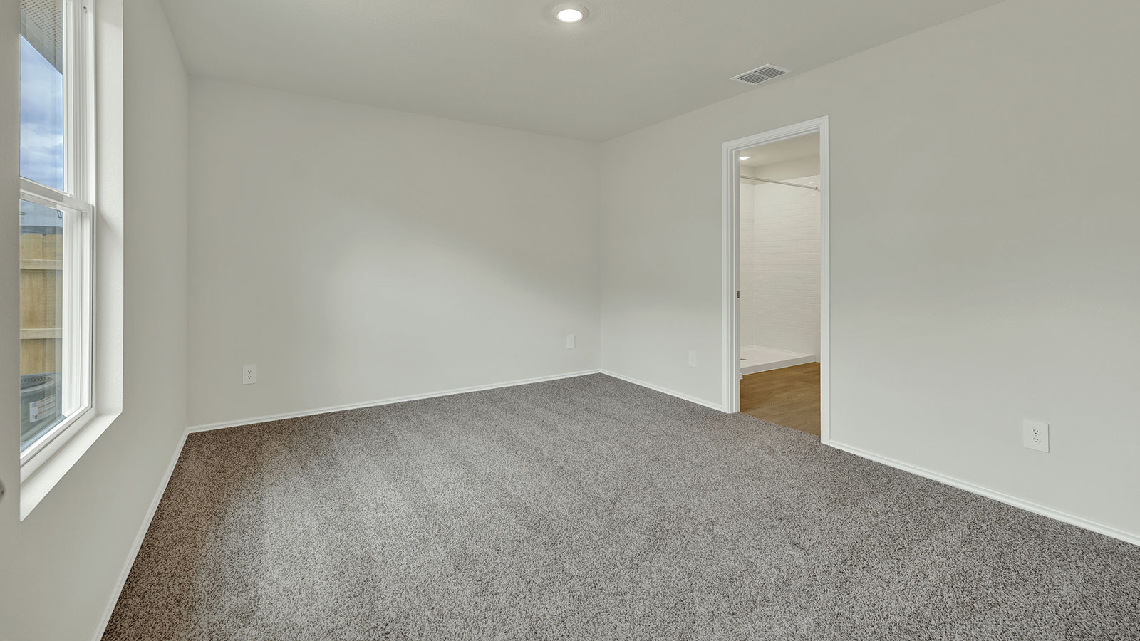 Main bedroom with carpeting and one window.