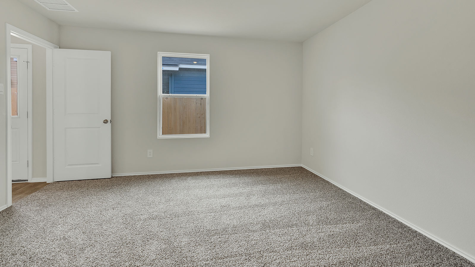 Main bedroom with carpeting and one window.
