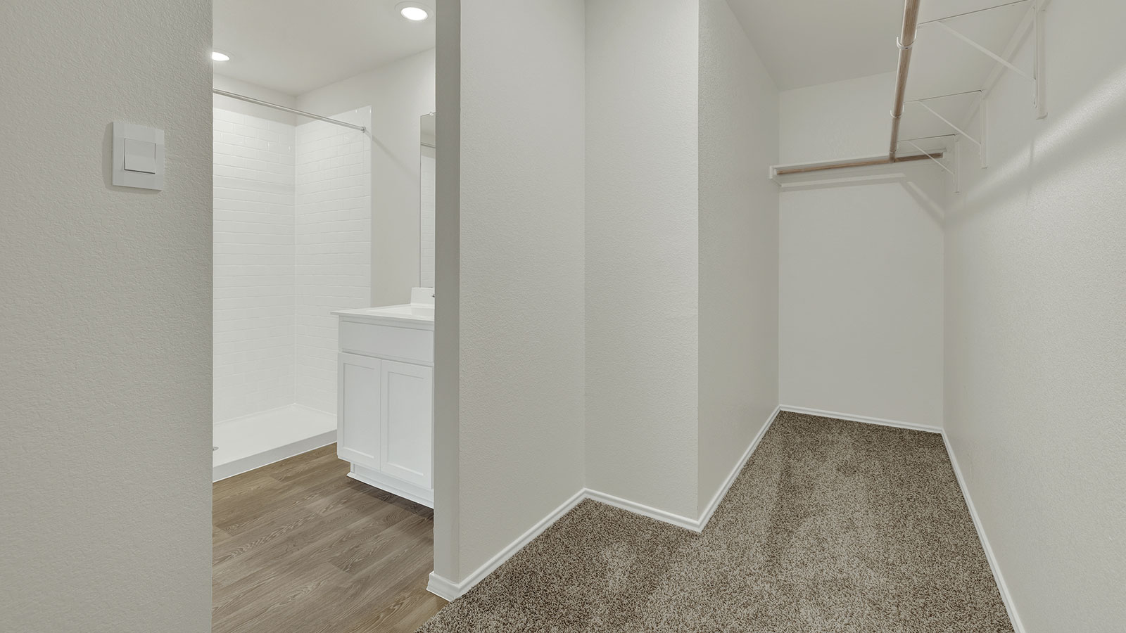 Main bedroom closet with carpeting and wooden shelving.