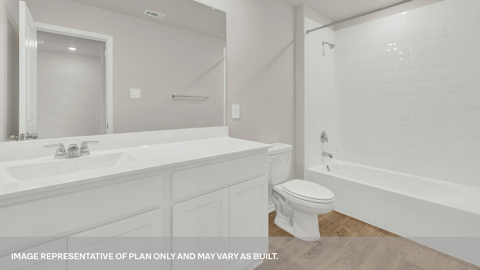 Hall bathroom with vanity, toilet, and tub with tile surround.