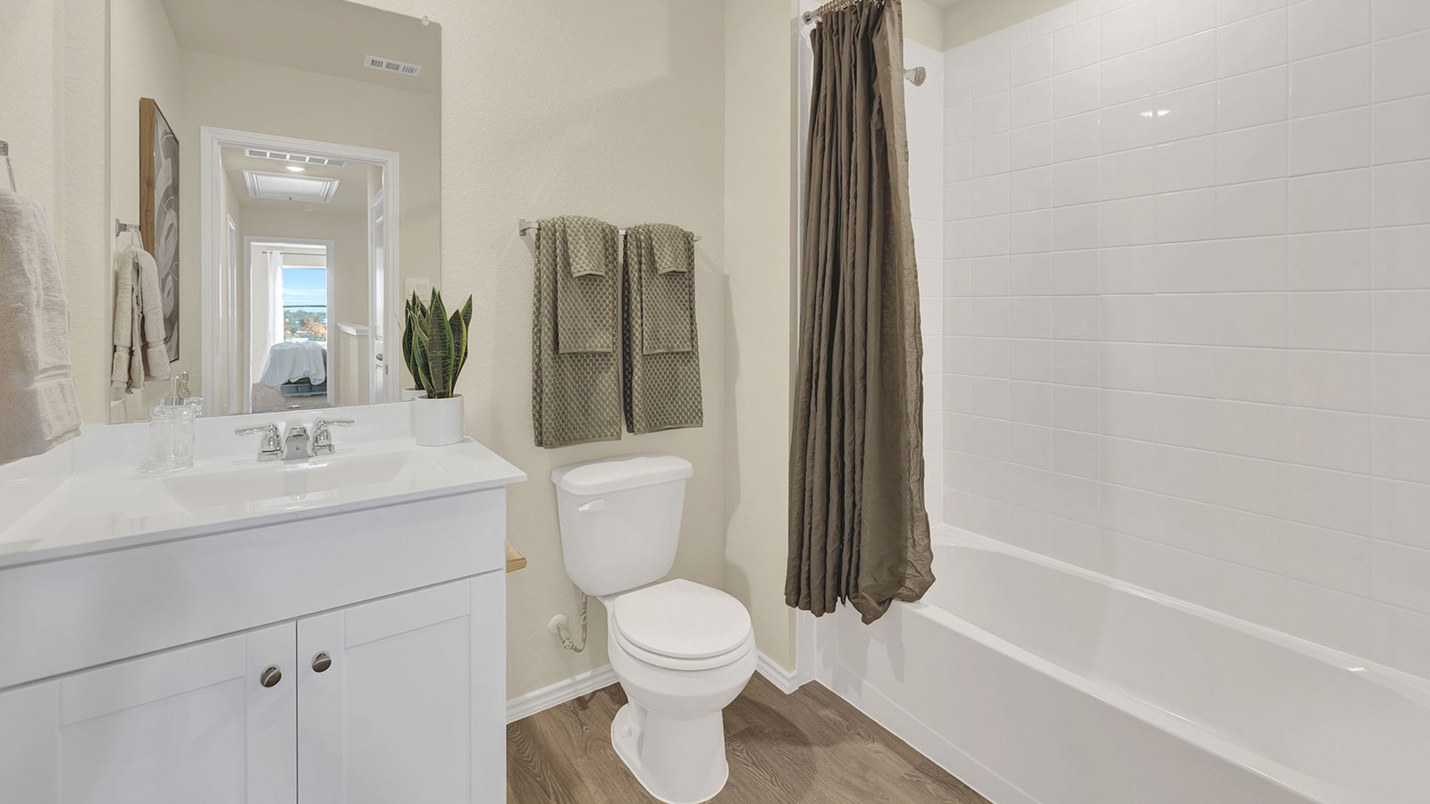 Hall bathroom with toilet, vanity, and shower.