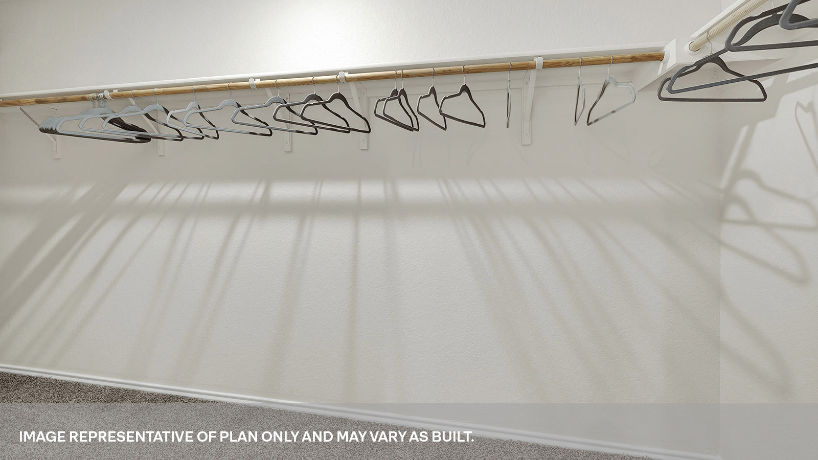 Main bedroom closet with carpeting and wooden shelving.