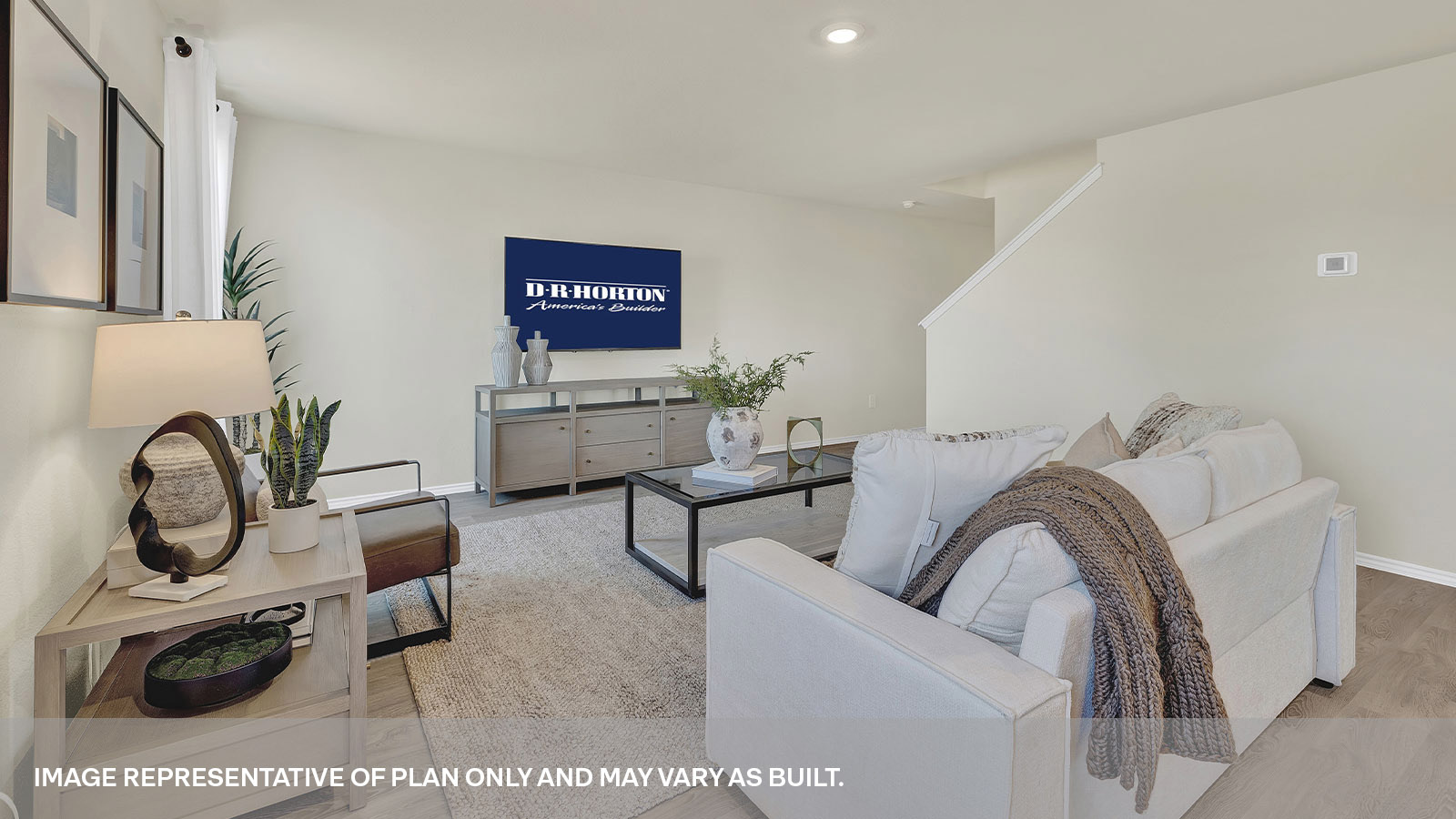 Living room with vinyl flooring and opening to the entry hallway and leading to the staircase.