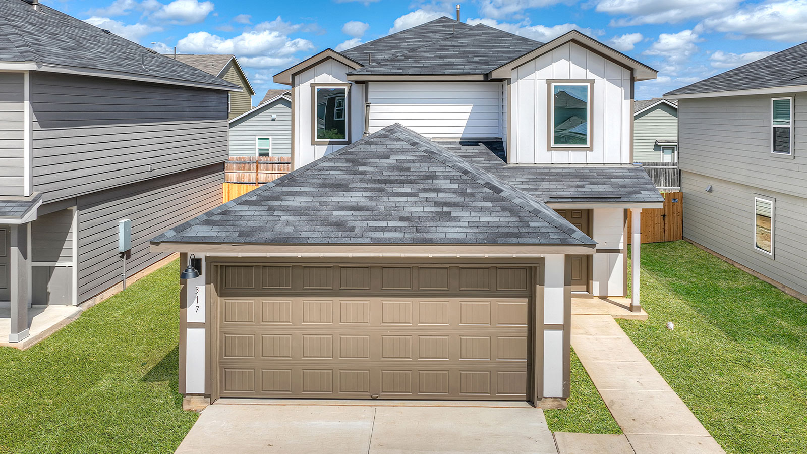 Two-story farmhouse exterior photo with 2 car garage.