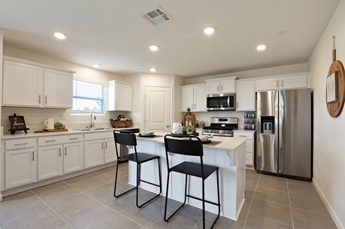 Bright kitchen with white shaker cabinets and island seating