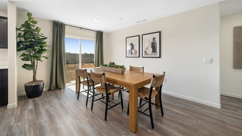 Interior photo of dining room with table, chairs, and large sliding glass door leading to the backyard