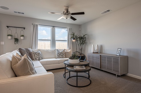 Interior photo of living room with couch, coffee table, and large windows.