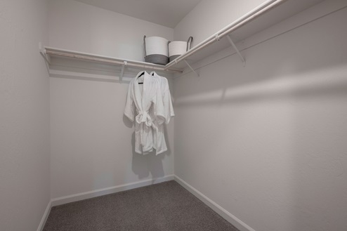 Interior photo of walk in closet attached to primary suite.