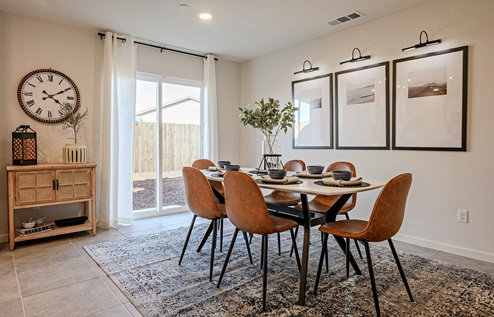 Interior photo of open concept dining room with dining table, chairs, and sliding glass door leading to backyard.