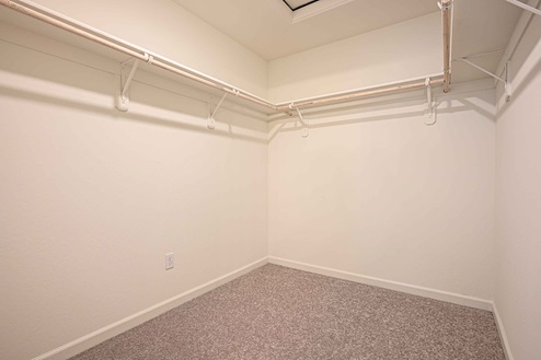 Interior photo of walk in closet attached to primary suite.