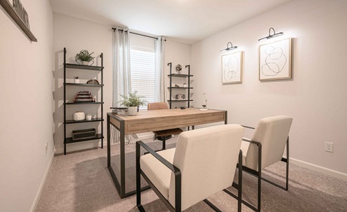 Interior photo of home office with desk, chairs, and a large window.