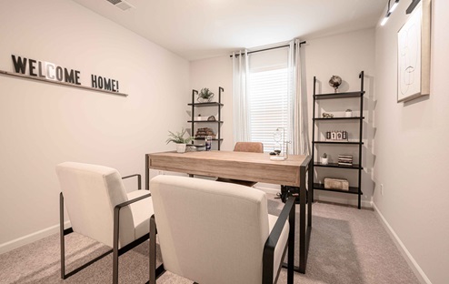 Interior photo of home office with desk, chairs, and a large window.
