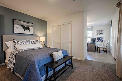 Interior photo of MultiGen bedroom with bed and end table