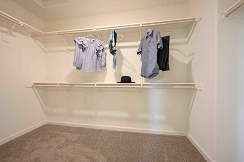 Interior photo of walk in closet attached to primary suite.