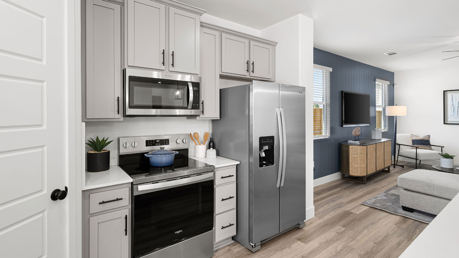 Kitchen with cabinetry, range, microwave, refrigerator, and expansive flooring