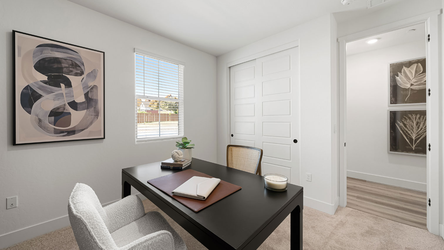 Home office with window, sliding closet doors, and plush carpeting