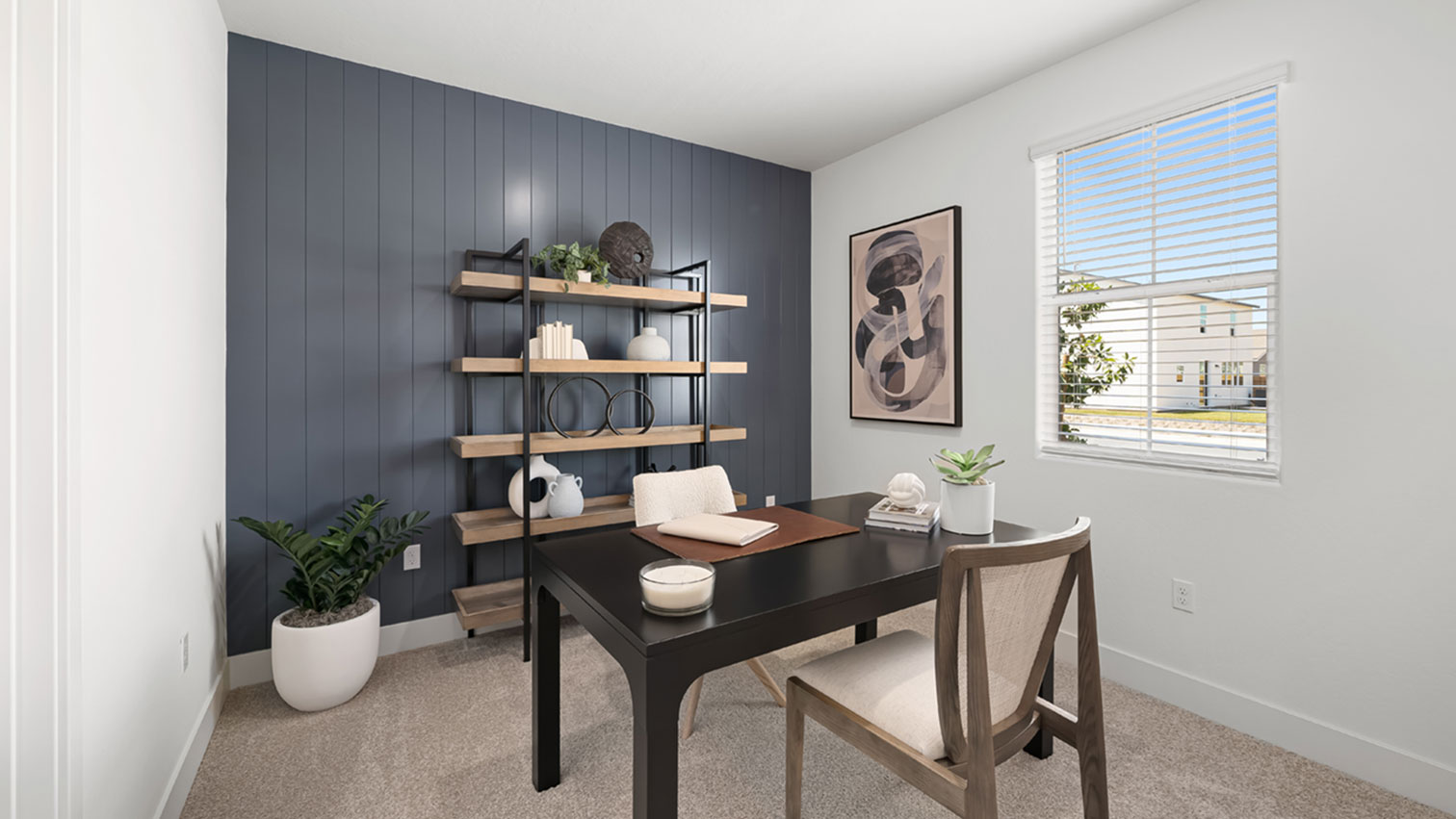 Home office with window, plush carpeting, and accent wall