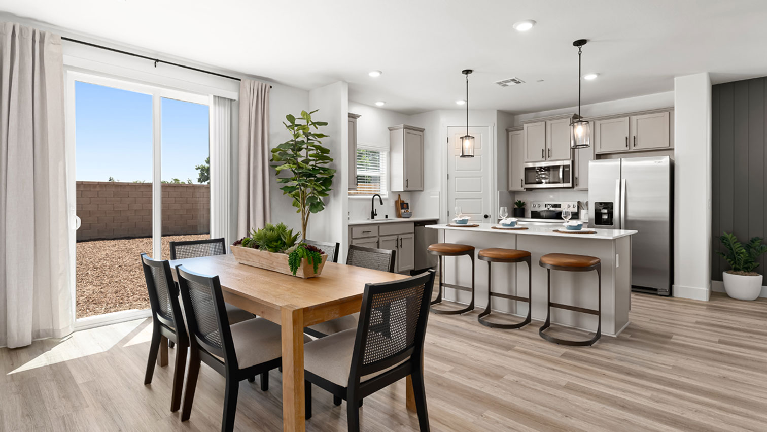 Open dining area and kitchen with center island, pendant lighting, large sliding glass door, and expansive flooring