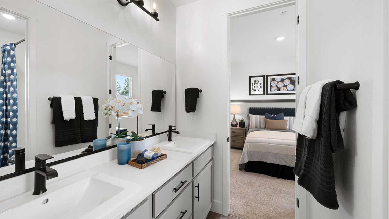 Bathroom with double vanity, mirrors, and bathtub shower combination