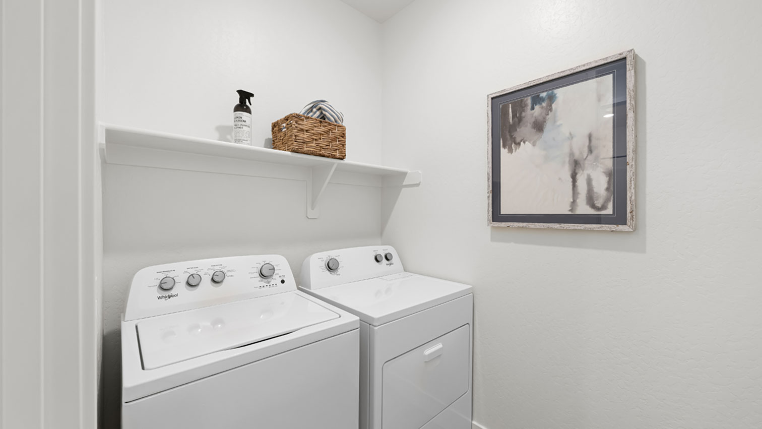 Laundry room with side-by-side washer and dryer and wall shelf