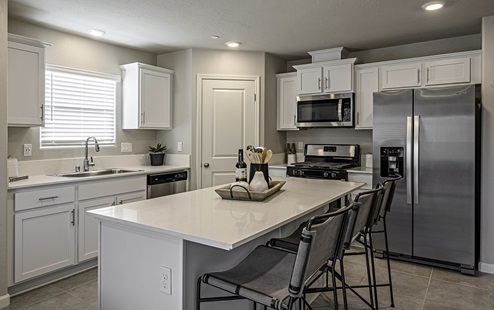 Kitchen with white cabinets and island seating