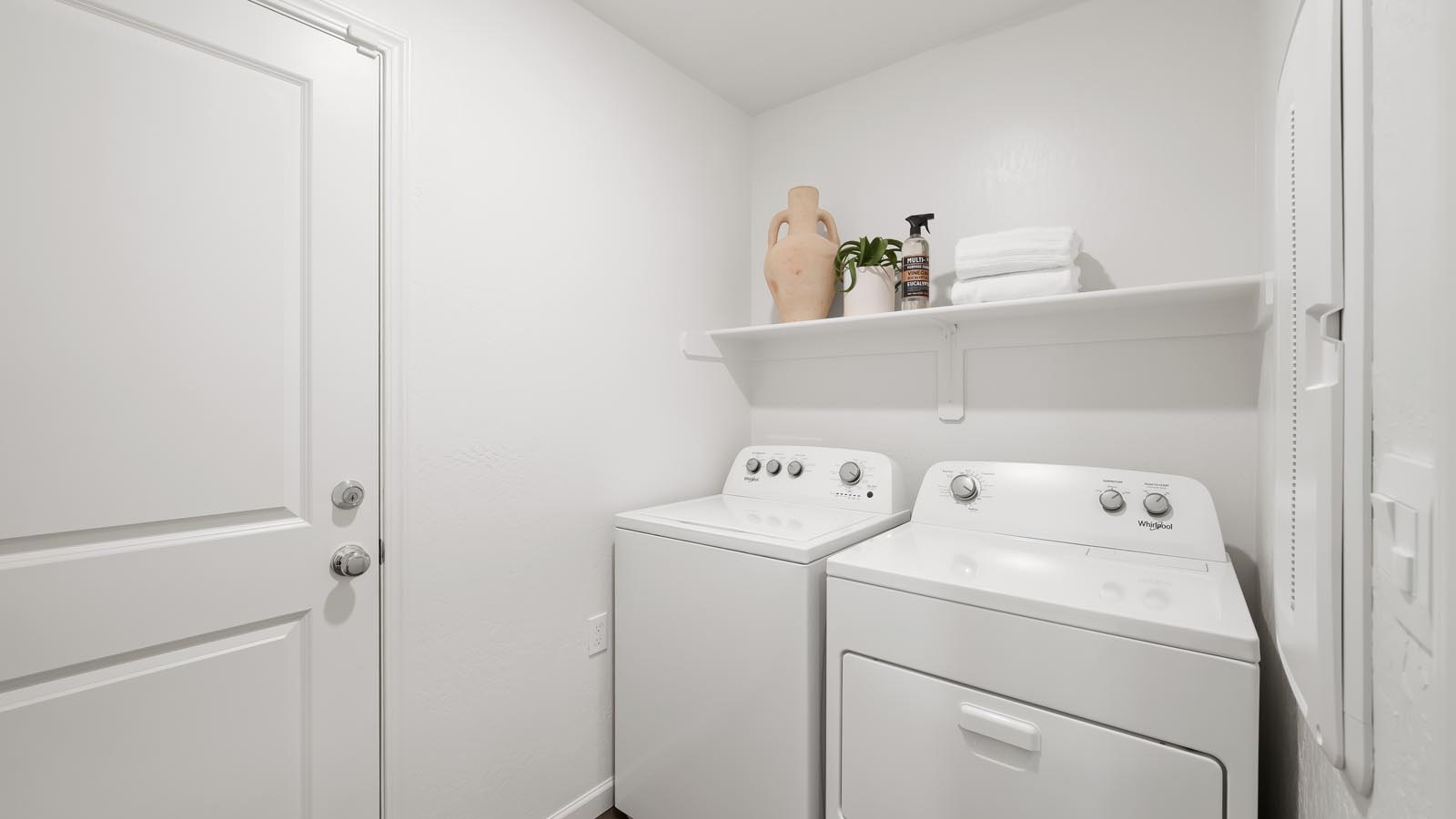 laundry room with washer, dryer, and storage shelf
