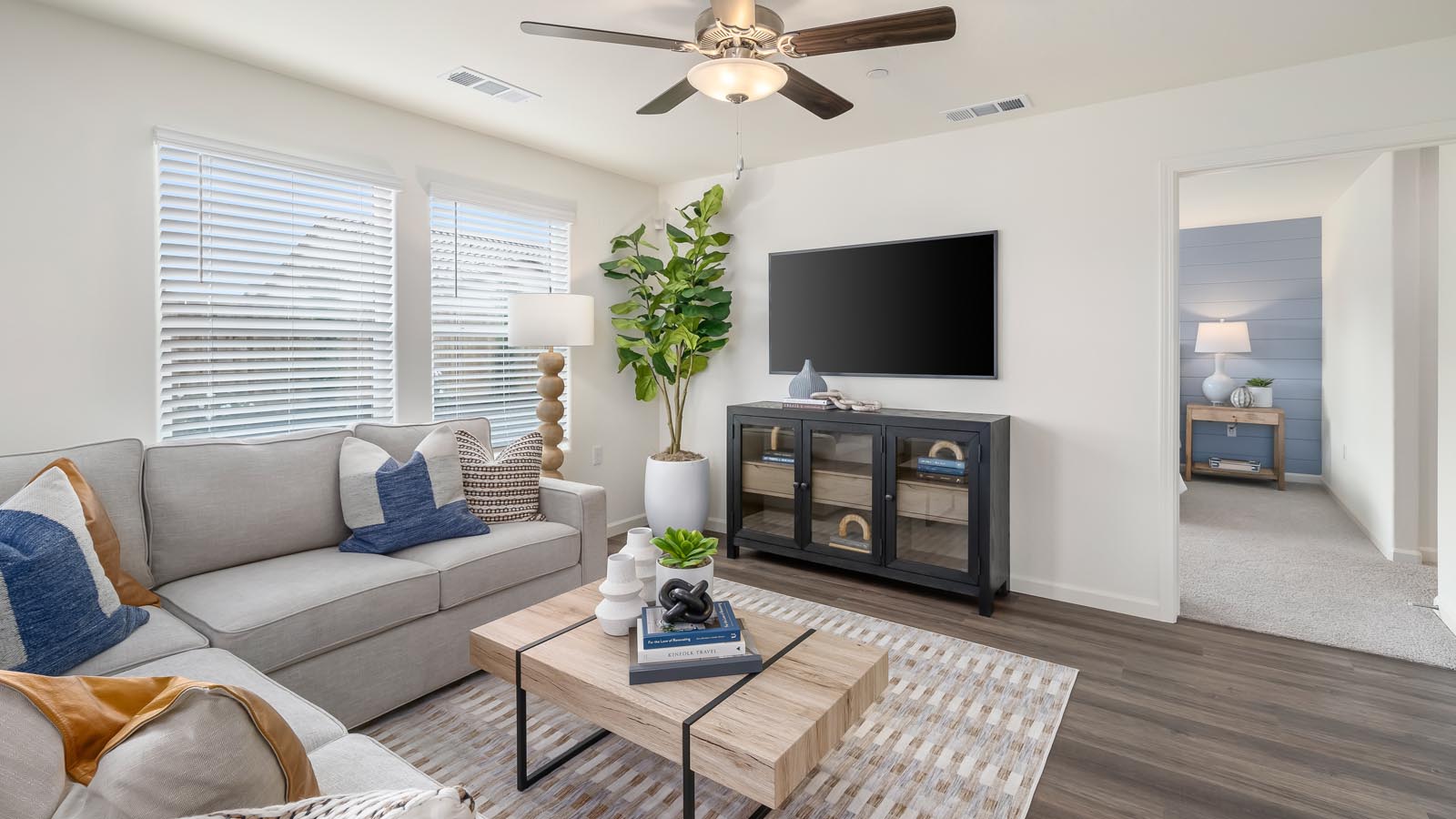 open concept living room with sectional and entertainment center