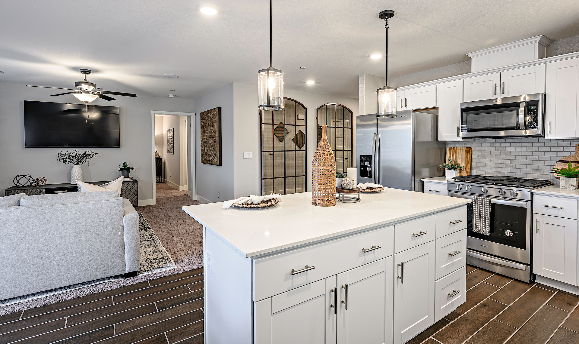 Interior photo of kitchen with white countertops, white cabinets, and stainless steel appliances.