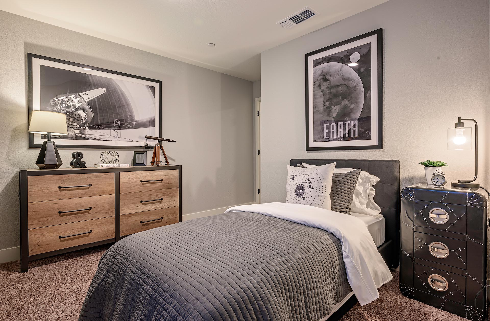 Interior photo of guest bedroom with bed, dresser, and end table.