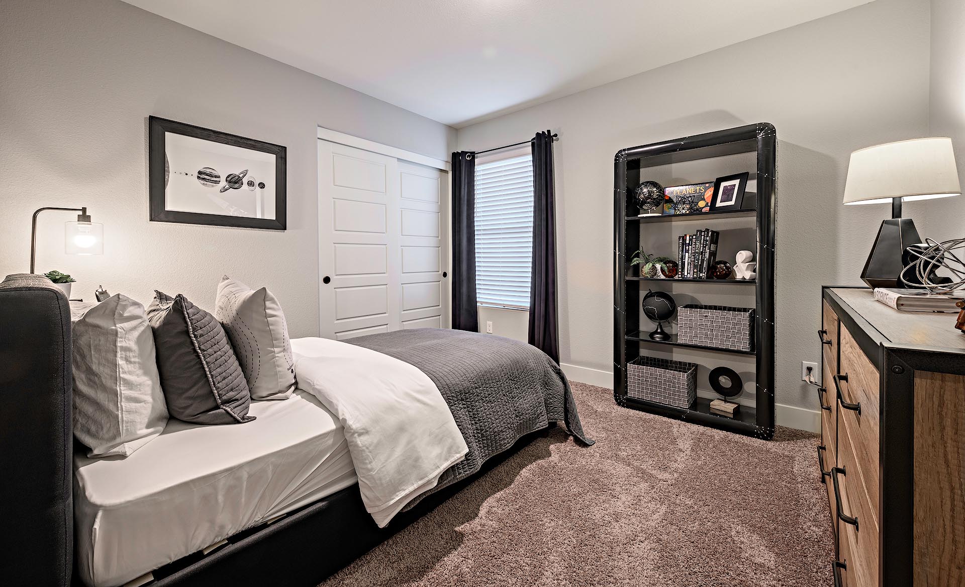 Interior photo of guest bedroom with bed, dresser, and end table.
