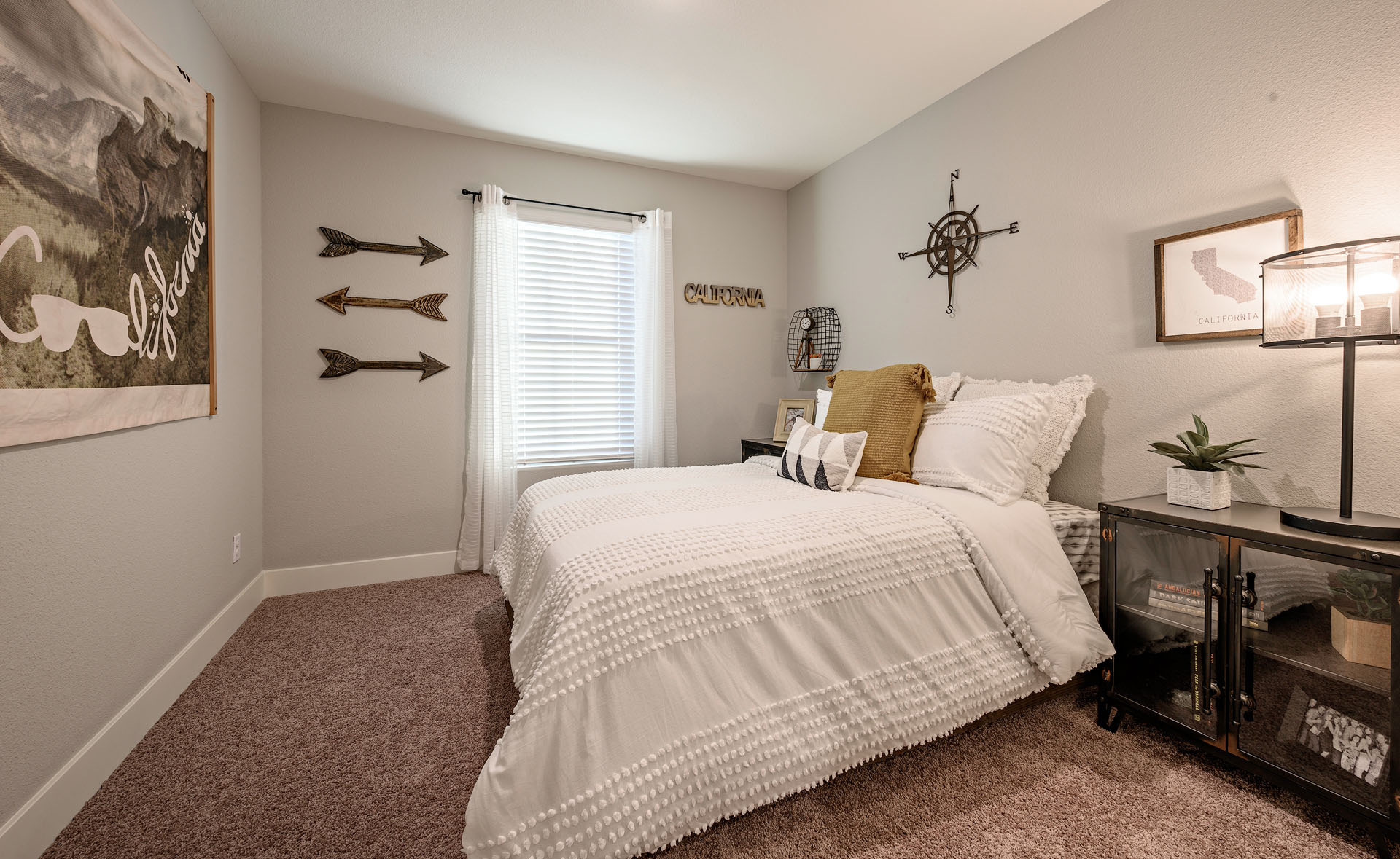 Interior photo of guest bedroom with bed, dresser, and end table.