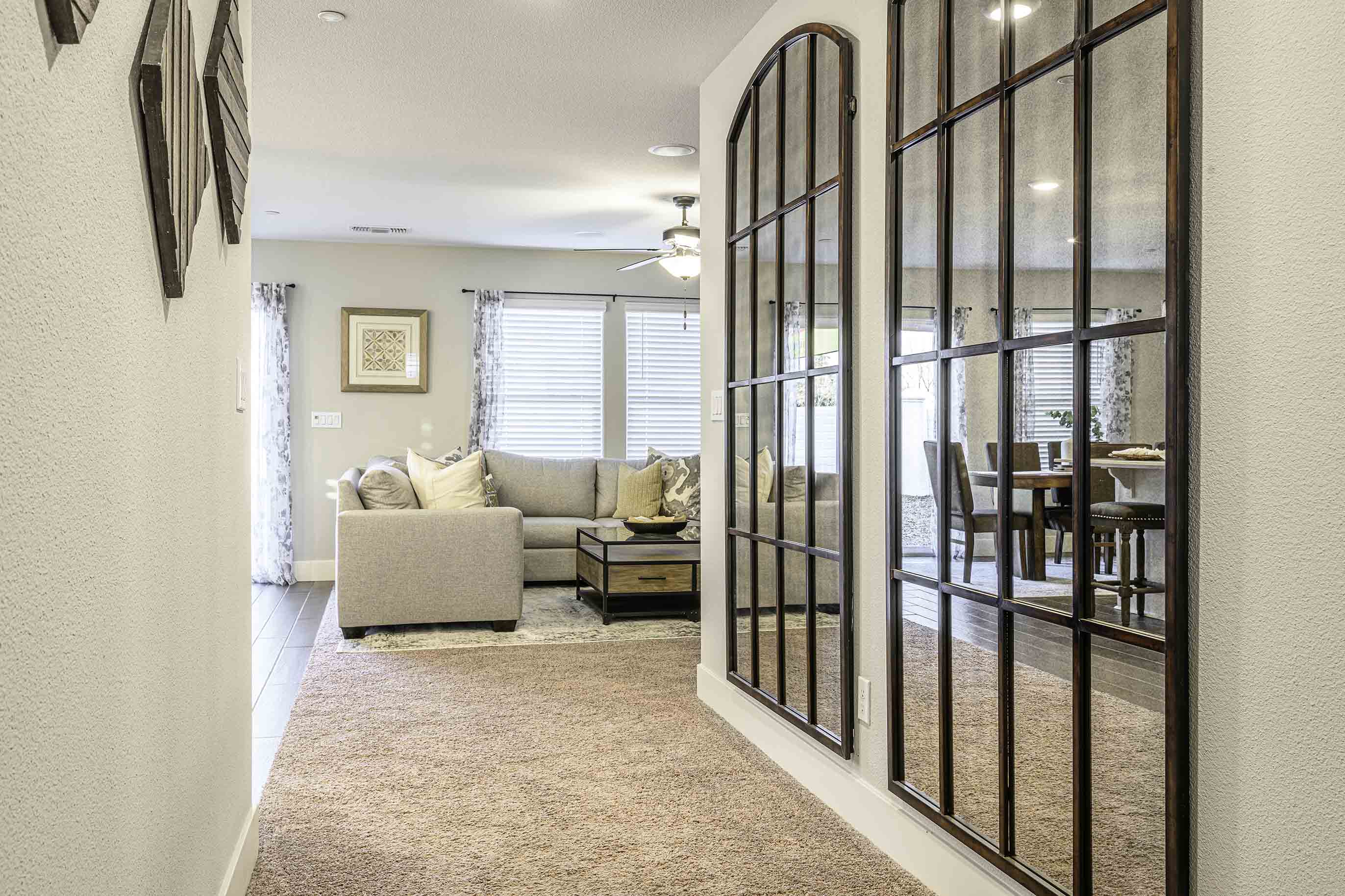 Interior photo of entryway to house with a hallway leading to the living room.