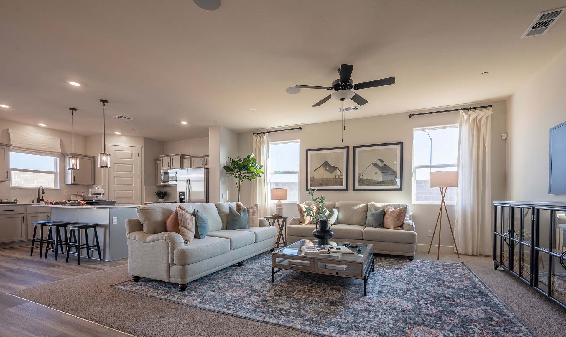 Interior photo of open concept living room with couch, coffee table, and large windows.