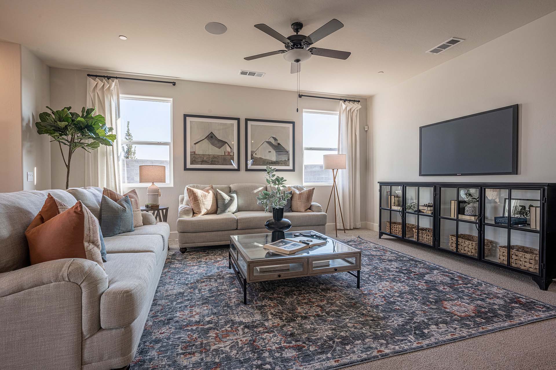 Interior photo of open concept living room with couch, coffee table, TV, and large windows.