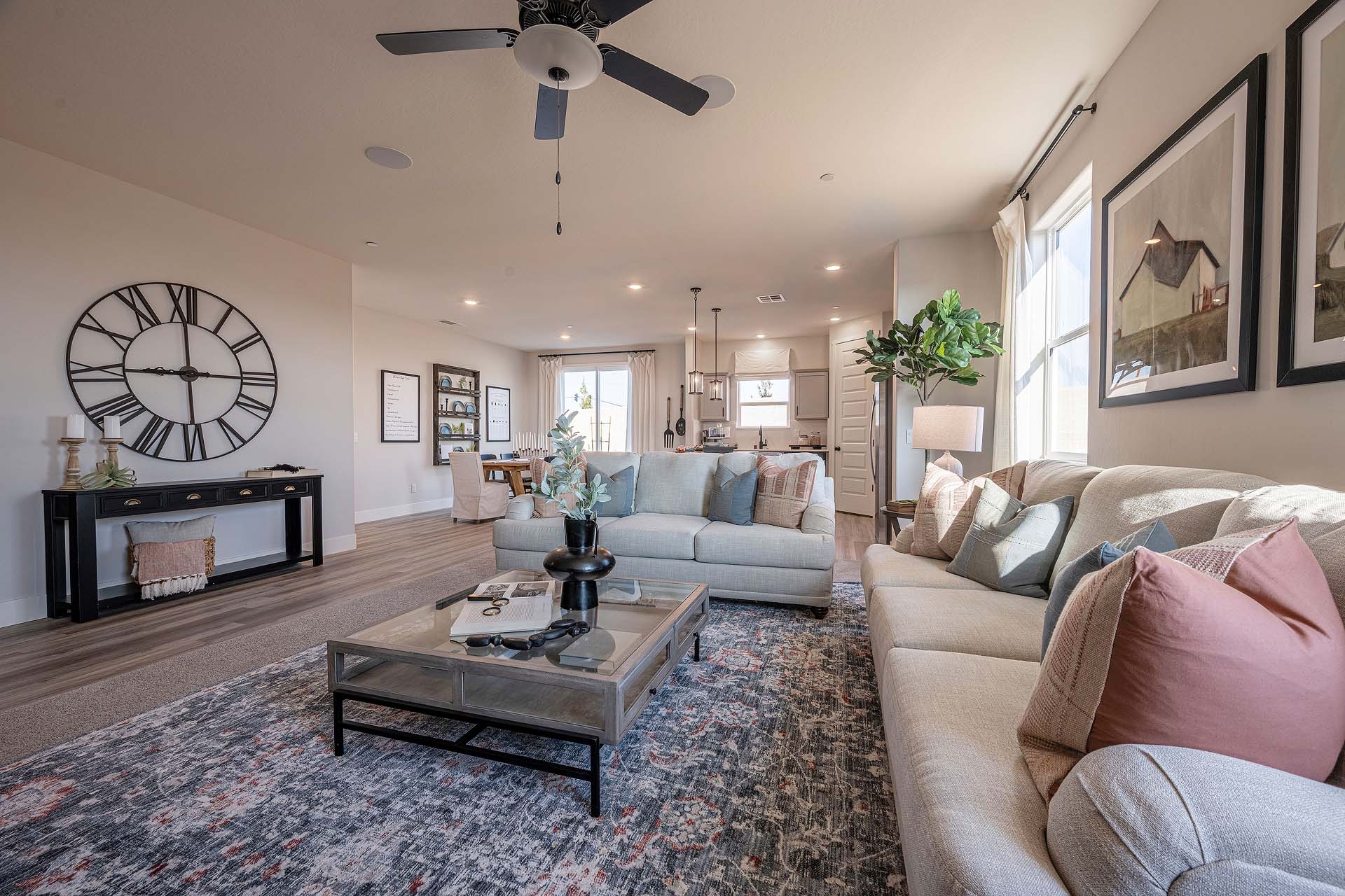 Interior photo of open concept living room with couch, coffee table, and large windows.