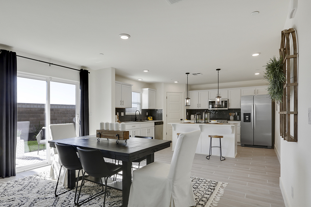 Interior photo of open concept dining room with dining table, chairs, and sliding glass door leading to backyard.