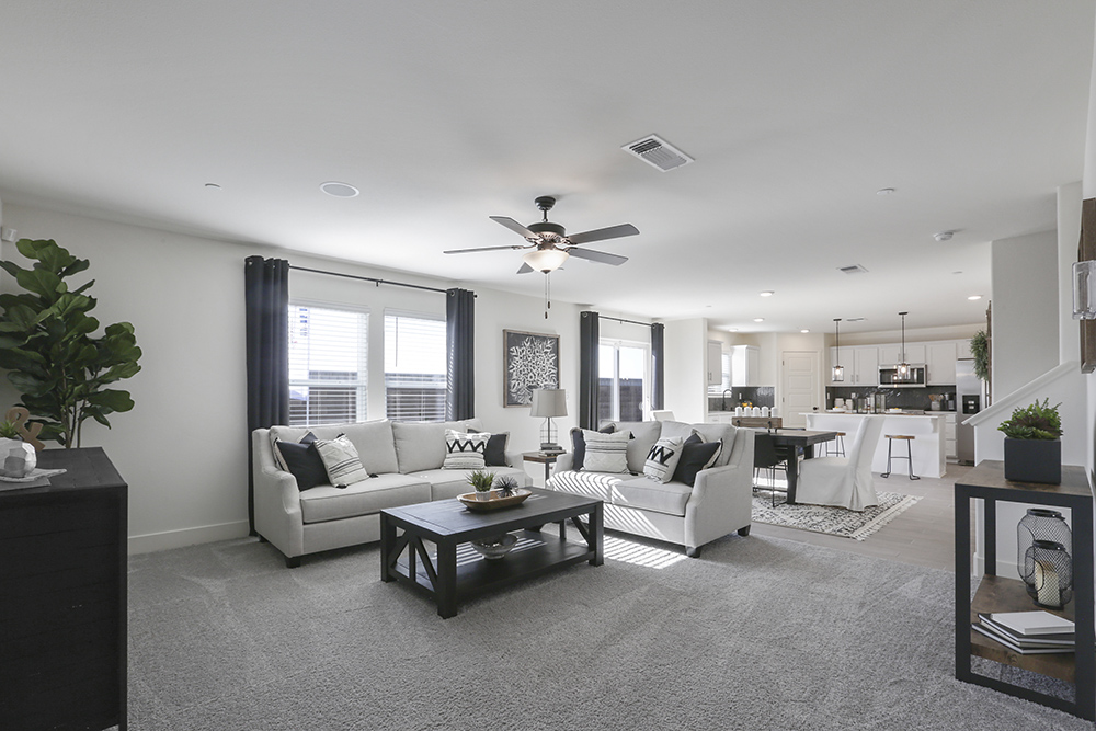 Interior photo of living room with large couch, coffee table, and large windows.