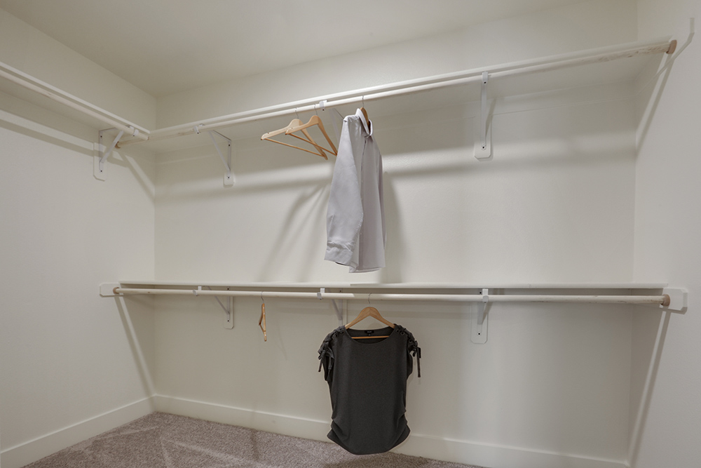 Interior photo of walk in closet attached to primary suite.