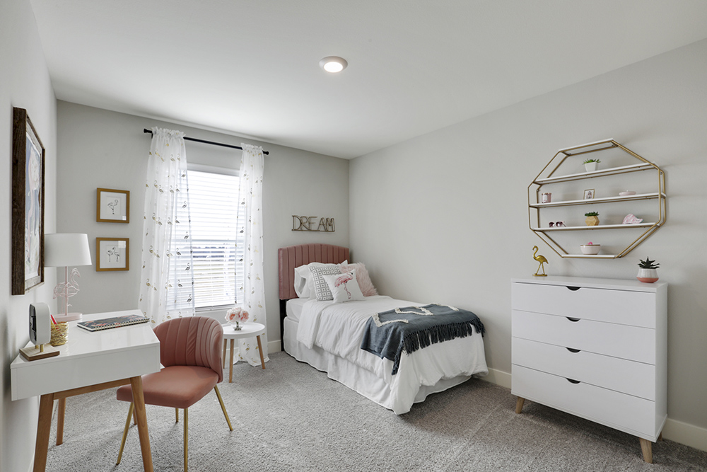 Interior photo of kid's bedroom with bed, dresser, chair, and large window.