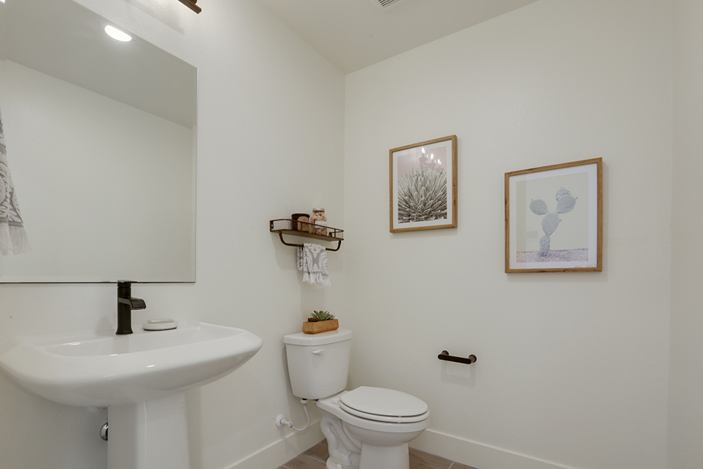 Interior photo of bathroom with sink, mirror, and toilet.