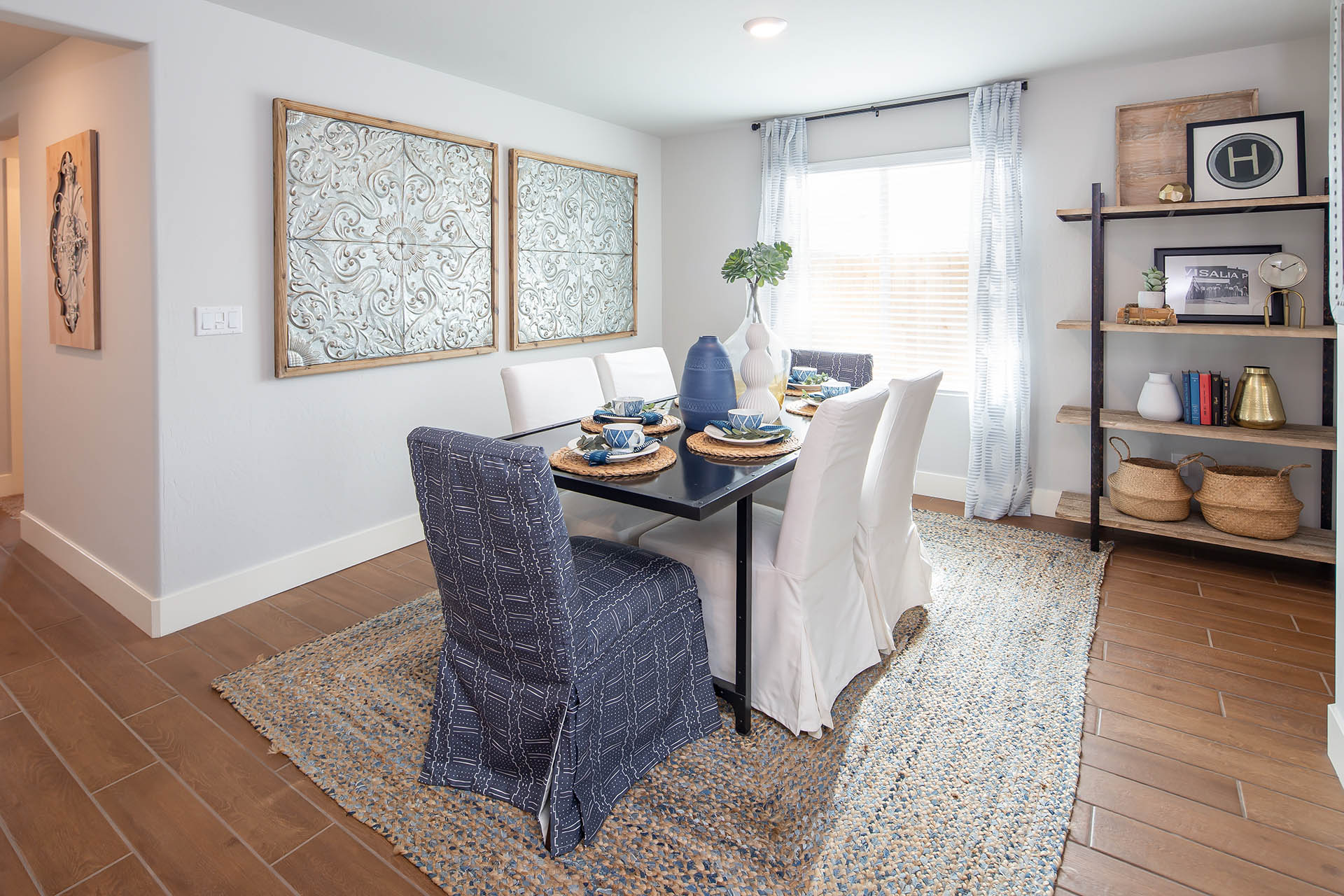 Interior photo of formal dining room with dining table, chairs, and large window.