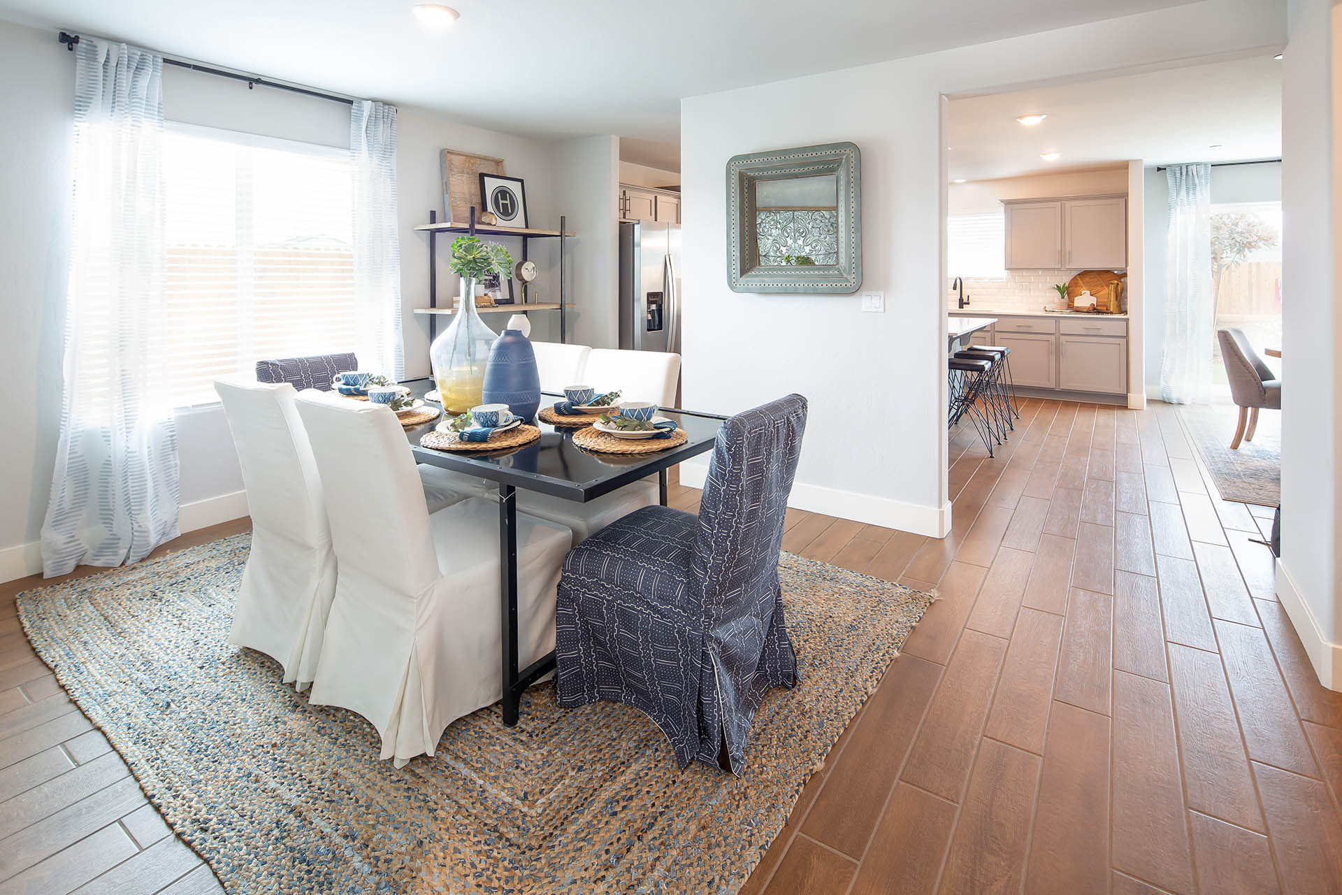 Interior photo of formal dining room with dining table, chairs, and large window.
