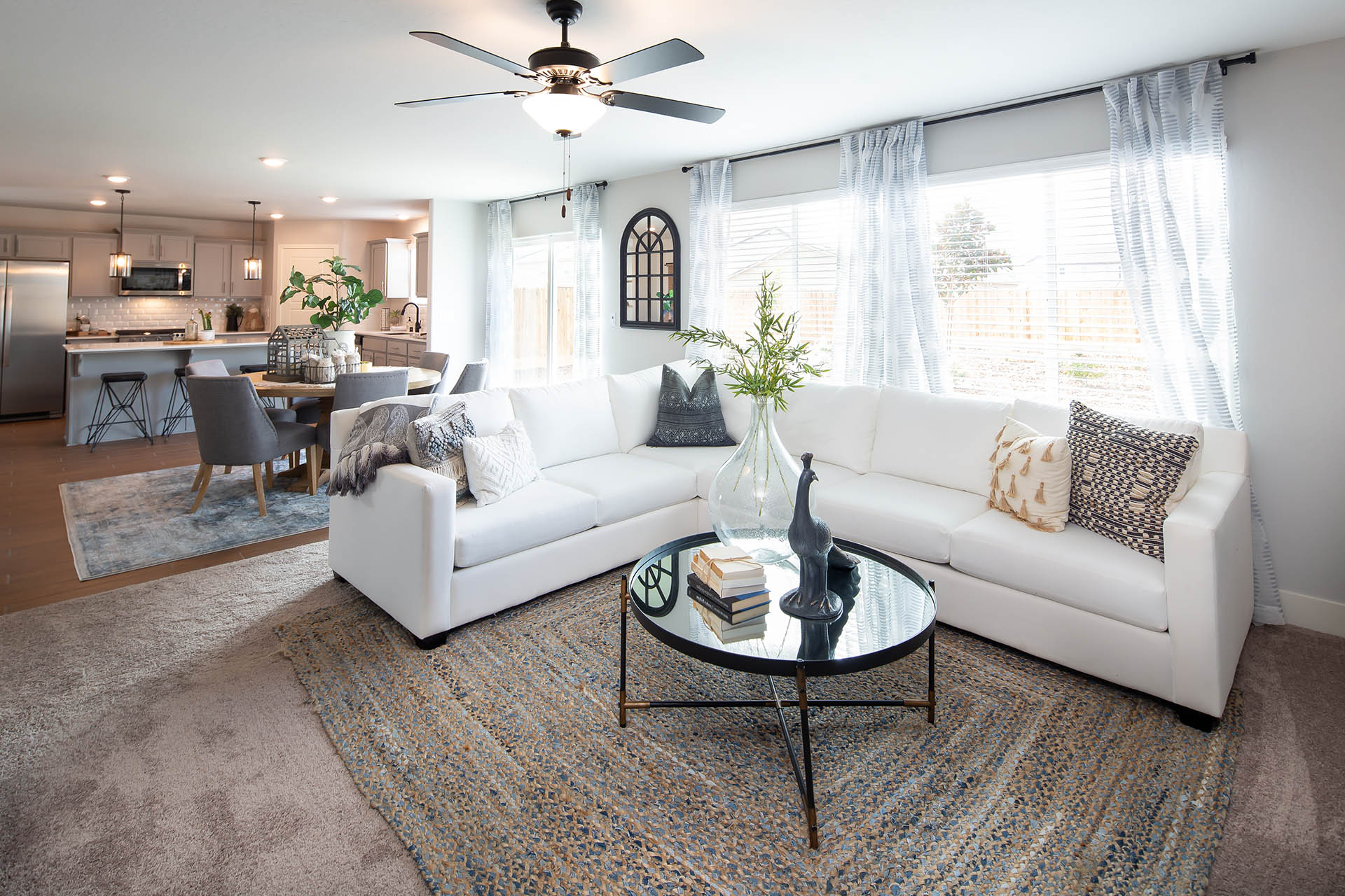 Interior photo of living room with large couch, coffee table, and large windows.