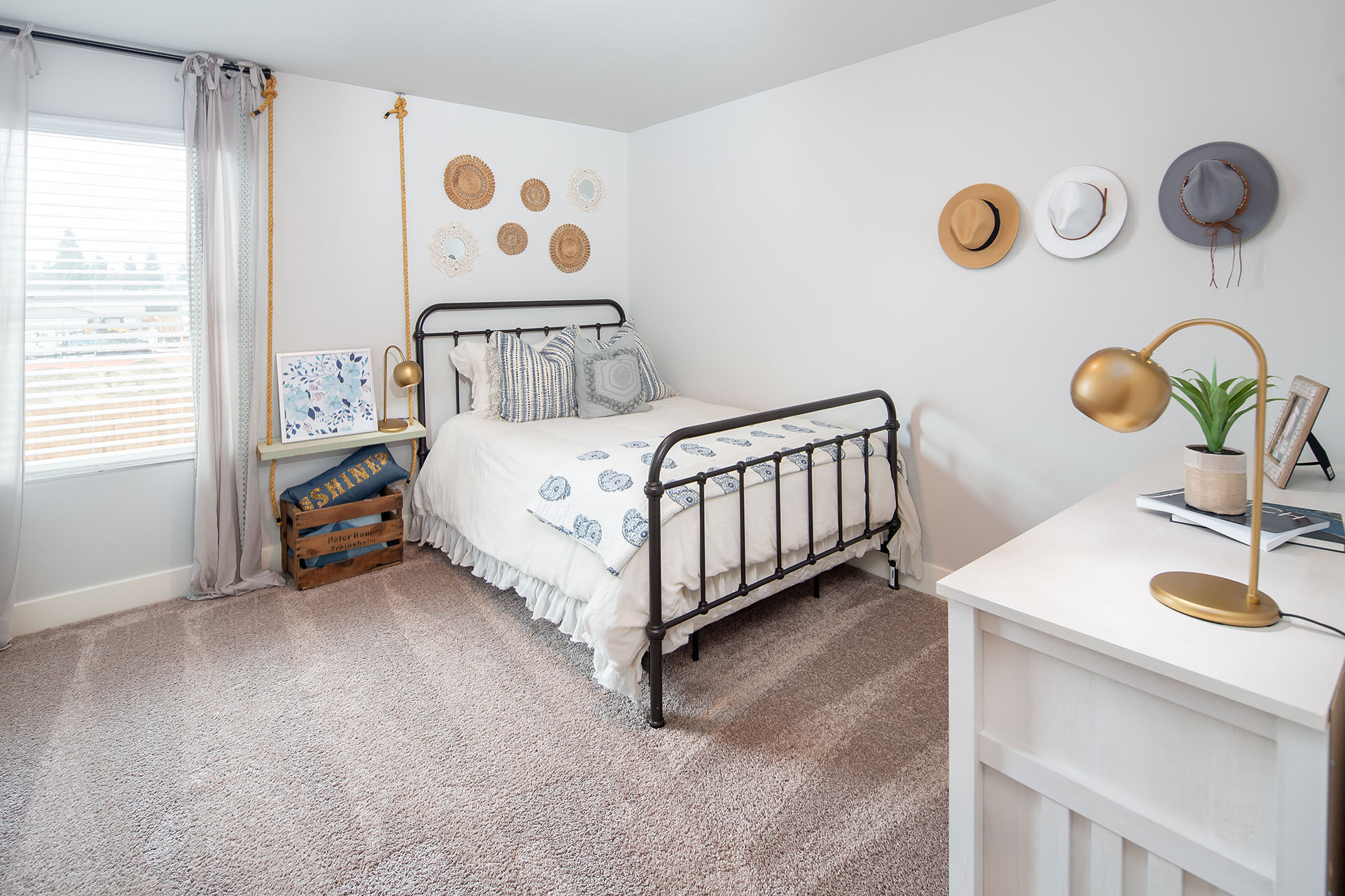 Interior photo of guest bedroom with bed, dresser, and large window.