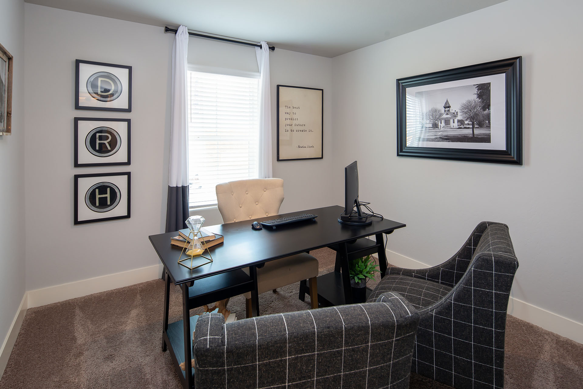 Interior photo of home office with desk, chairs, and large window.