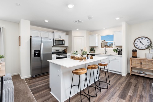 Kitchen with white cabinets and island seating