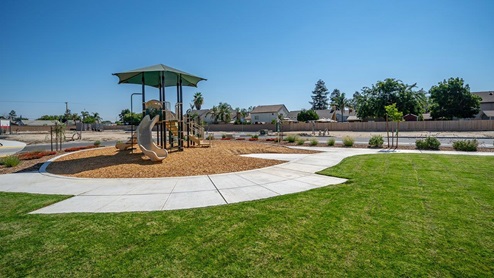 Photo of community park with grass and a playground